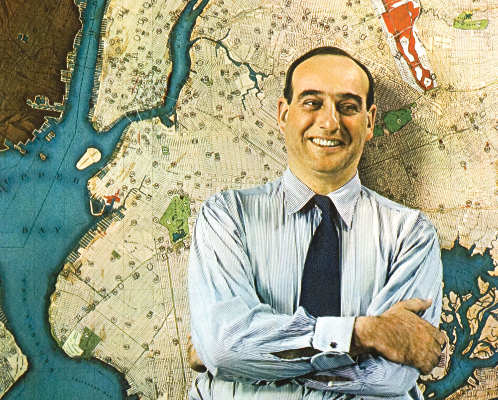 Young Robert Moses standing in front of a map of New York City