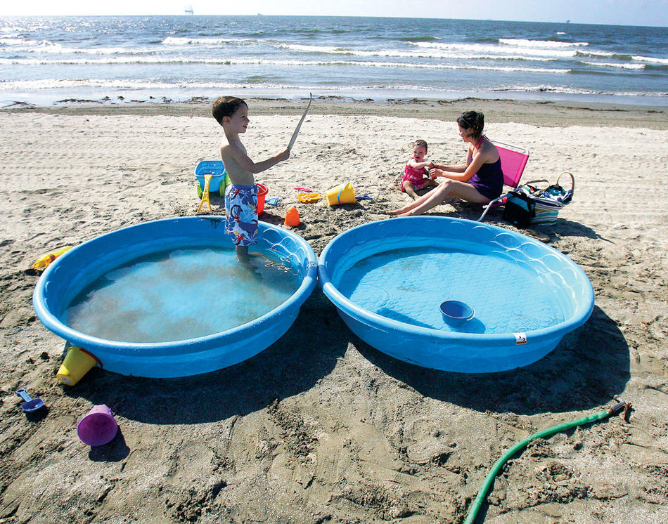 Gulf Coast resident Bridget Hargrove and her family wade in pools away from contaminated ocean water in Grand Islae, La., on May 21. (Reuters / Sean Gardner)