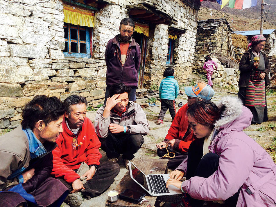 Tsechu Dolma surveys a group of Tibetan refugees in Nepal as part of her work with the Mountain Resiliency Project