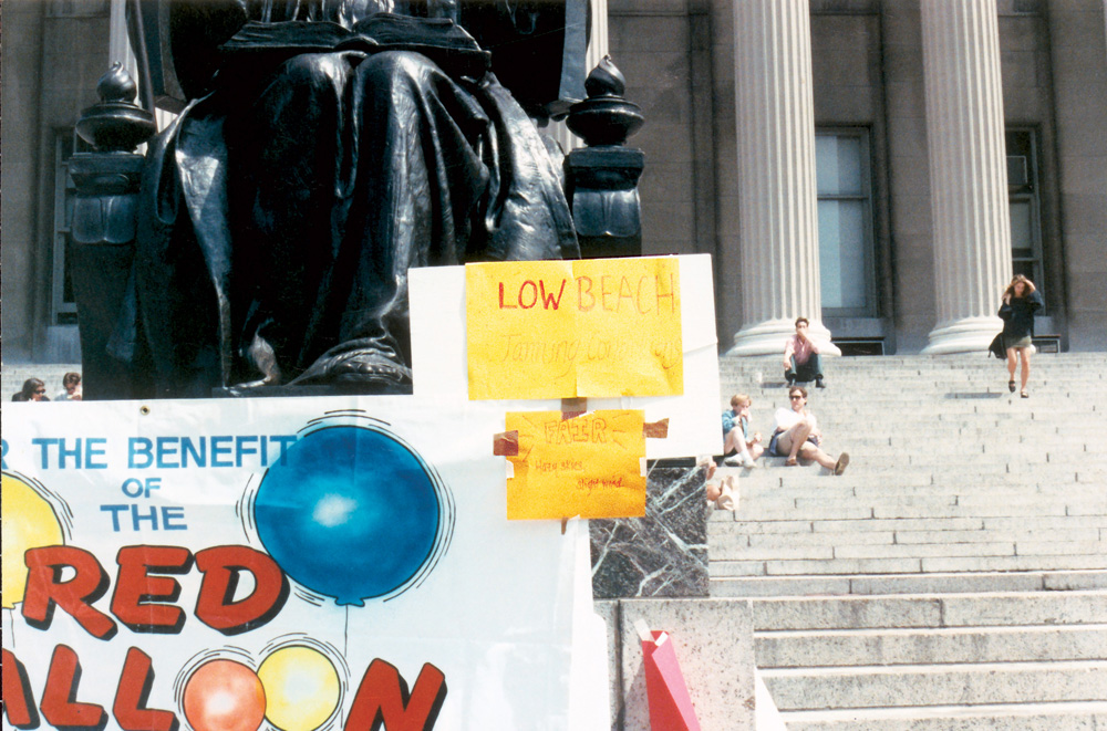 Alma Mater statue on Columbia Low Library stairs in the 1980s, with a sign about weather conditions