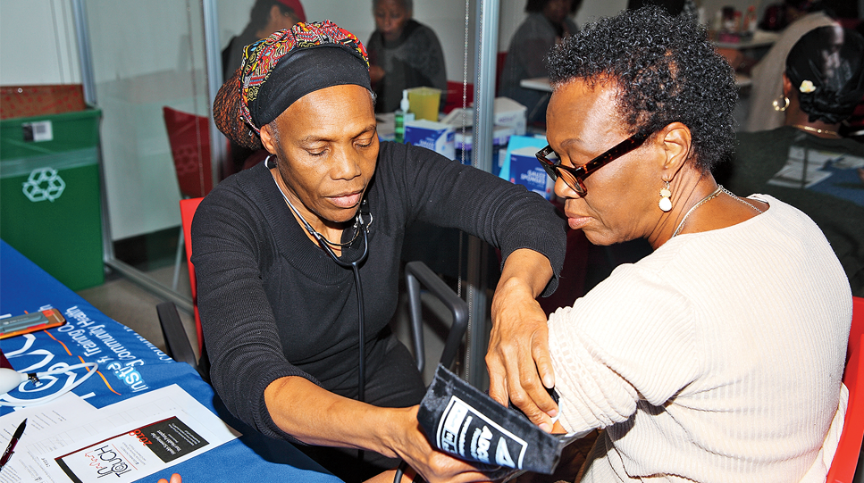 A health worker at Columbia's Community Wellness Center takes a patient's blood pressure