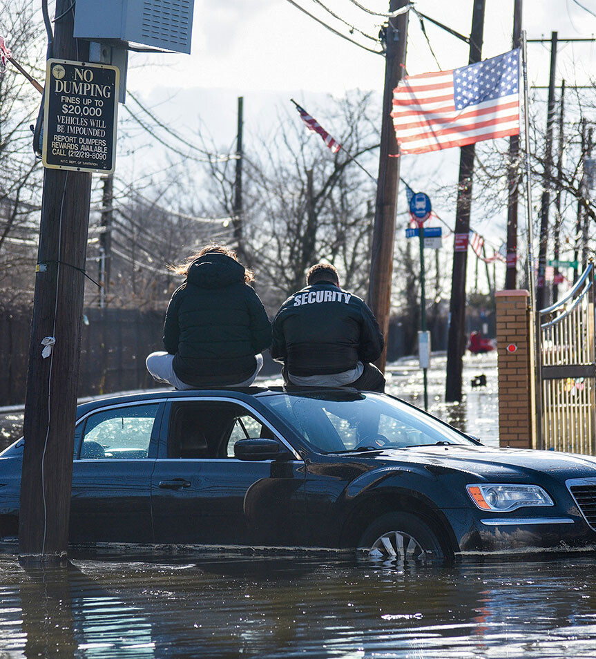 People sitting on a car during a flood