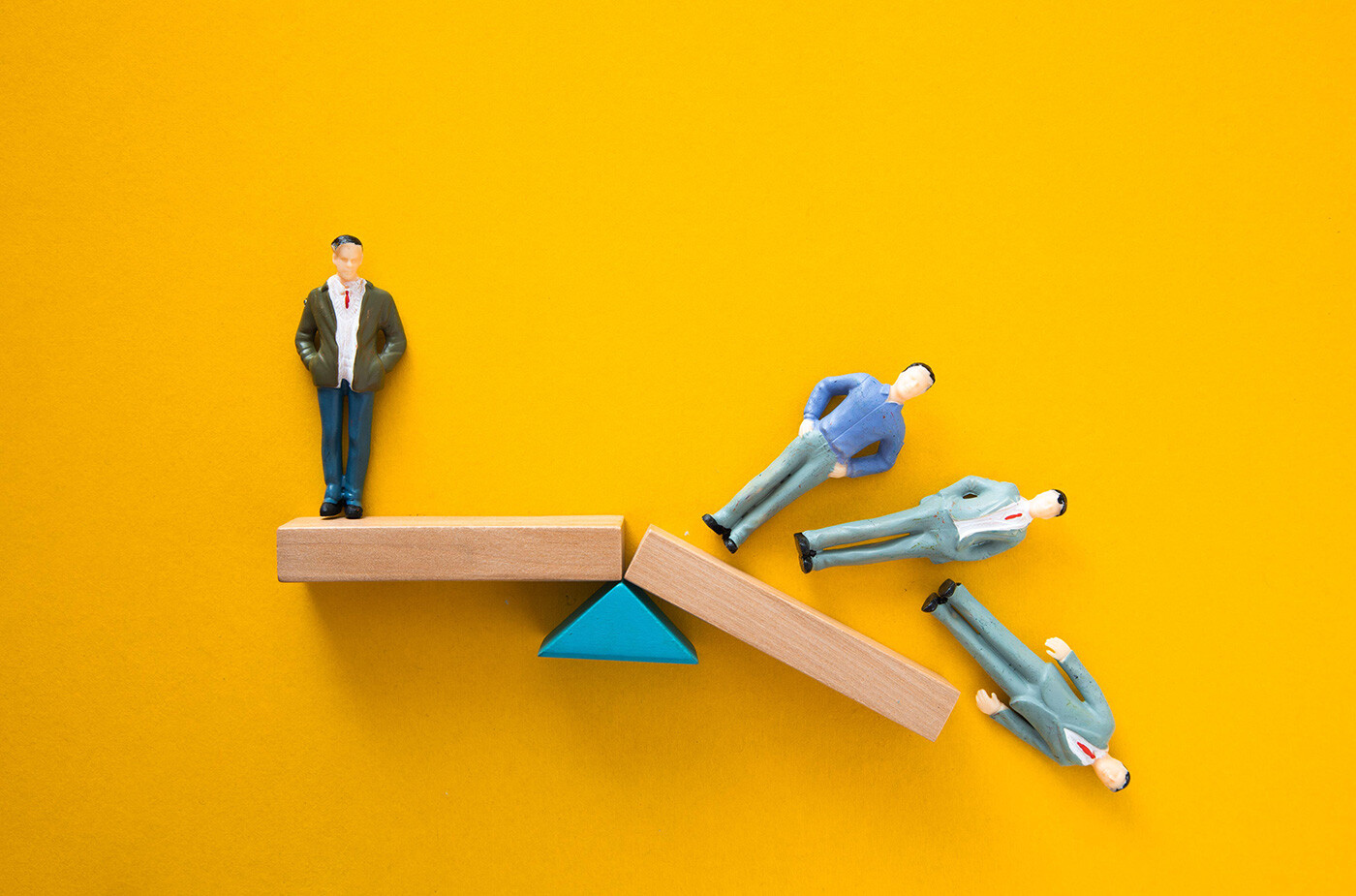 image of imbalanced toy figures on a see-saw