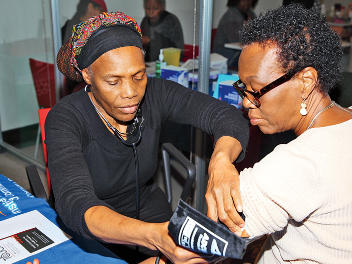 A health worker at Columbia's Community Wellness Center takes a patient's blood pressure