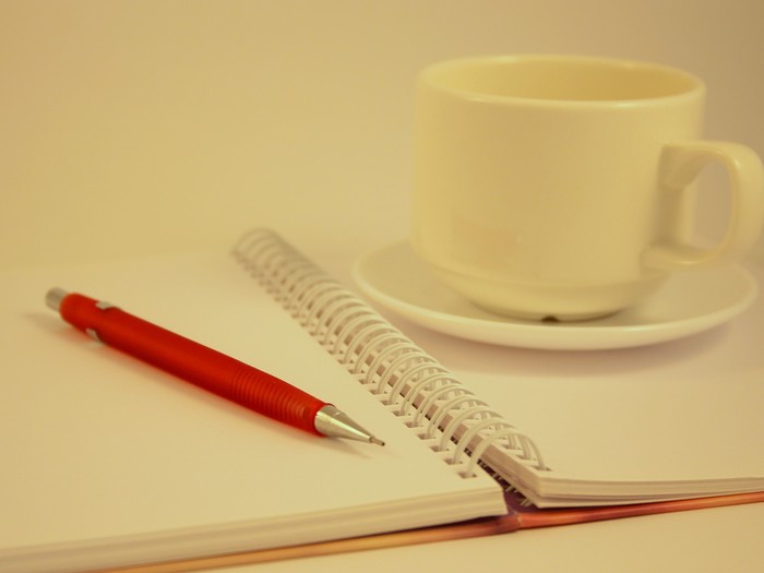 Photo of notebook, pen, and coffee cup