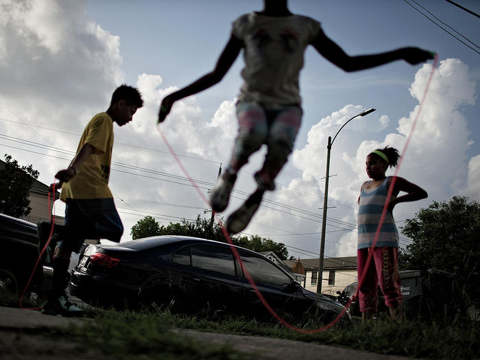 Children jumping rope on city sidewalk