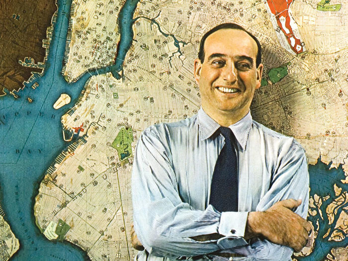 Young Robert Moses standing in front of a map of New York City