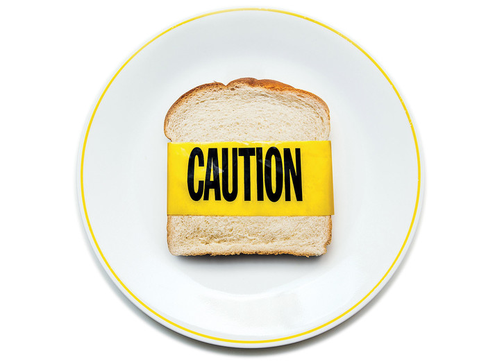 A piece of bread with caution tape to illustrate gluten sensitivity 