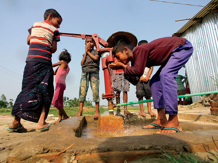 Children drinking water from a well in Bangladesh