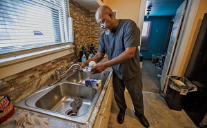 A man at his kitchen faucet
