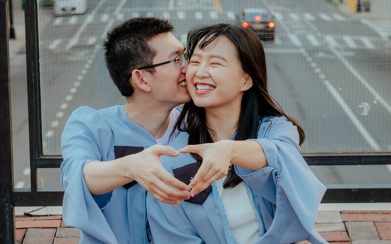 A couple in Columbia University commencement gowns on Revson Plaza