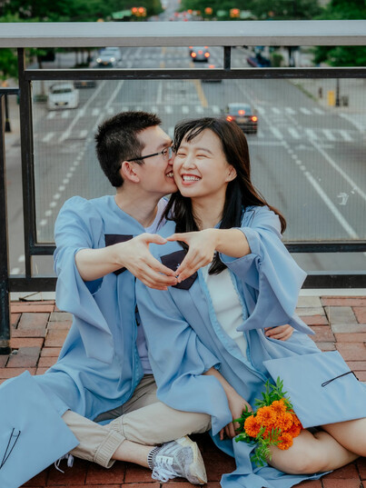 A couple in Columbia University commencement gowns on Revson Plaza