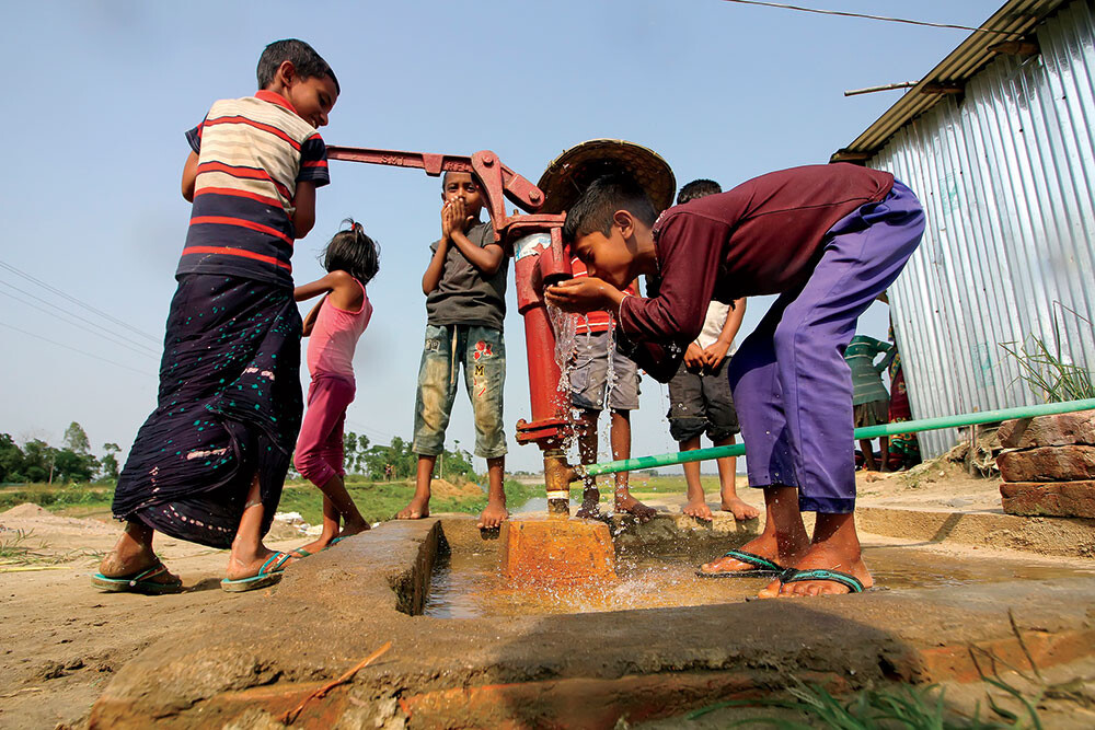Children drinking water from a well in Bangladesh