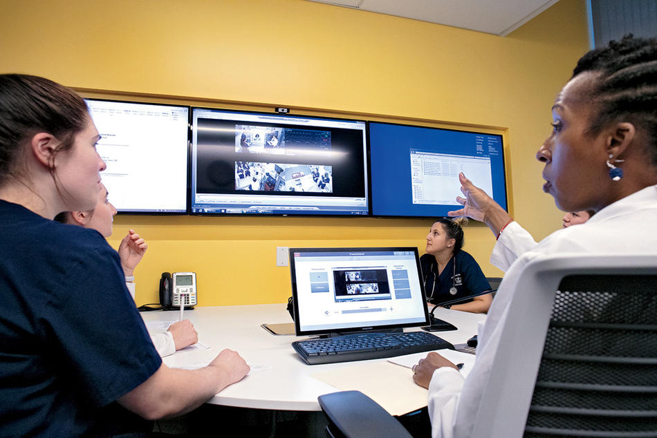 Students at Columbia Nursing School discuss their performance following a simulation exercise.