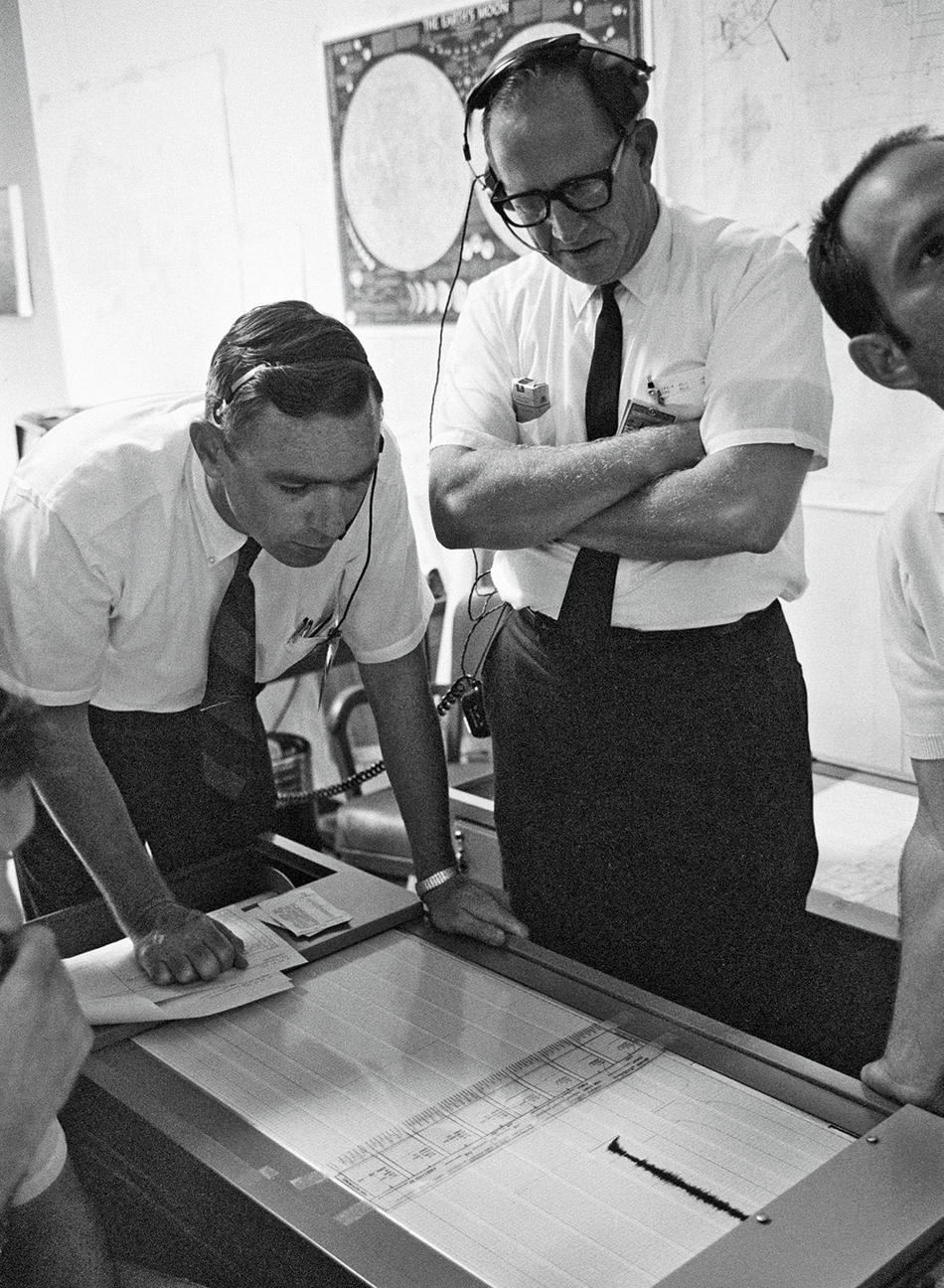 Gary Latham (left) monitors the signal from his experiment.