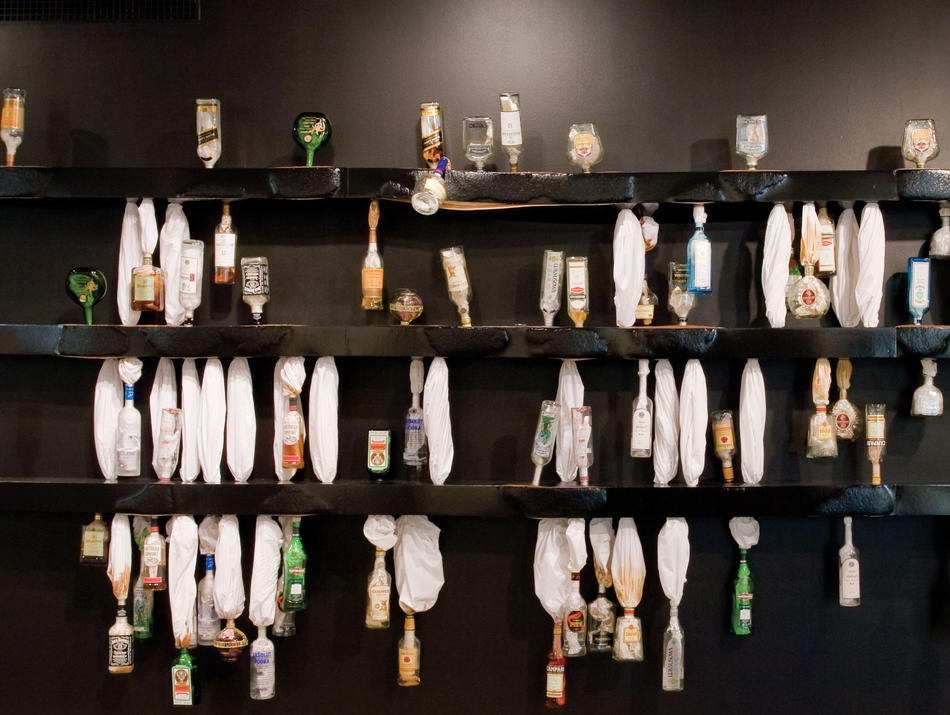 "Sweat," by Naama Tsabar (installation with bedsheets, liquor bottles, and shelves).