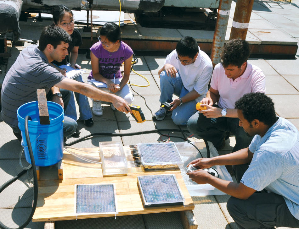 Columbia engineering students and local high schoolers examine solar panels to be installed at Frederick Douglass Academy in Upper Manhattan