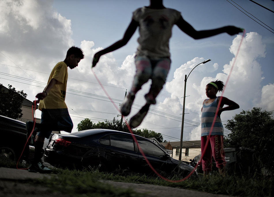Children jumping rope on city sidewalk