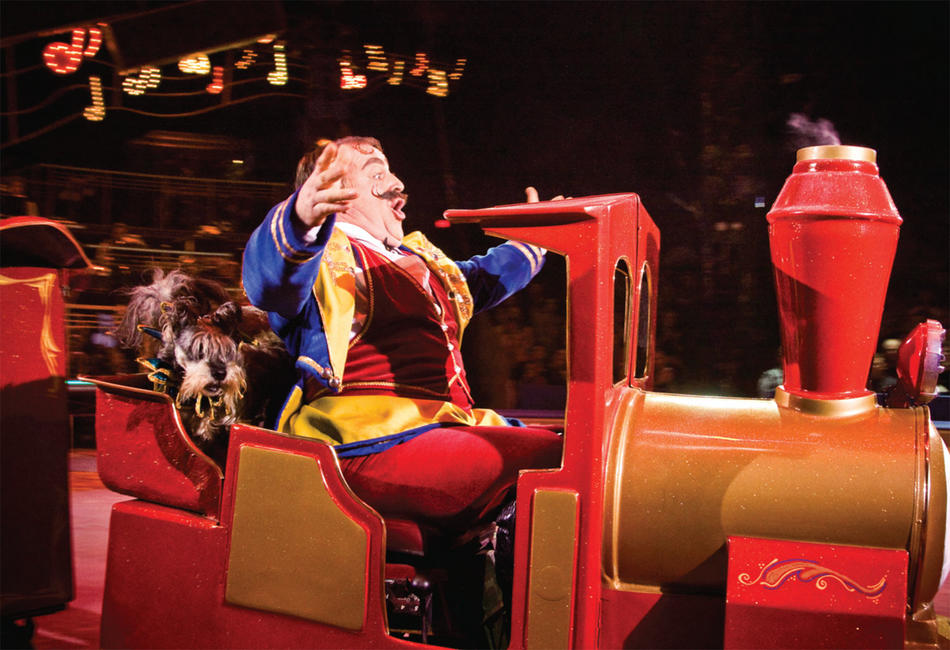 Performer at the Big Apple Circus riding a train with a dog