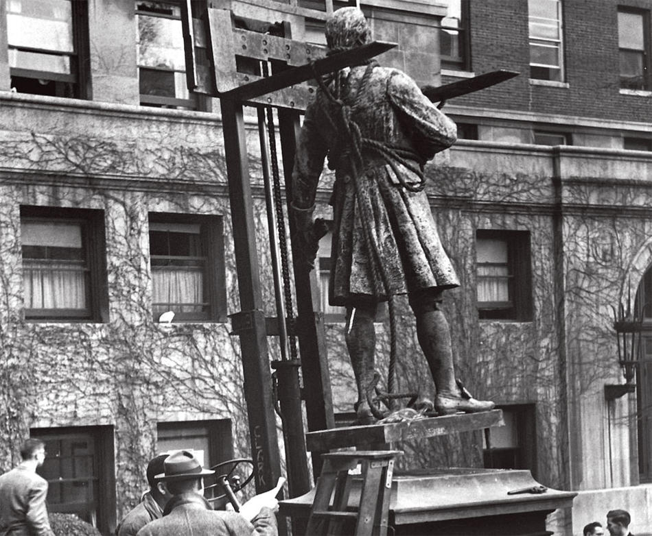 Historic photo of workers installing a sculpture of Alexander Hamilton on Columbia campus, outside Hamilton Hall