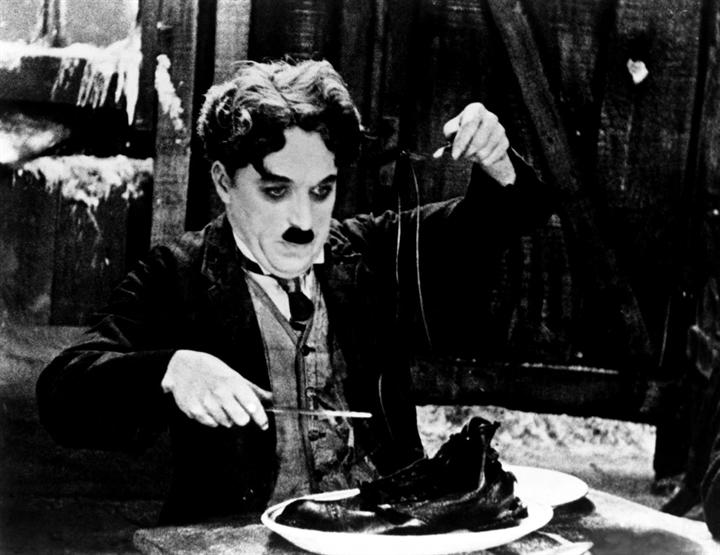 Charlie Chaplin digs into a boot in "The Gold Rush" (1925)