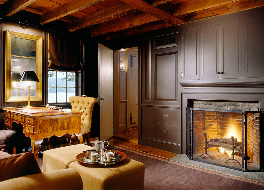 Photo of a living room with a fireplace, wood ceiling, and 18th-century furniture