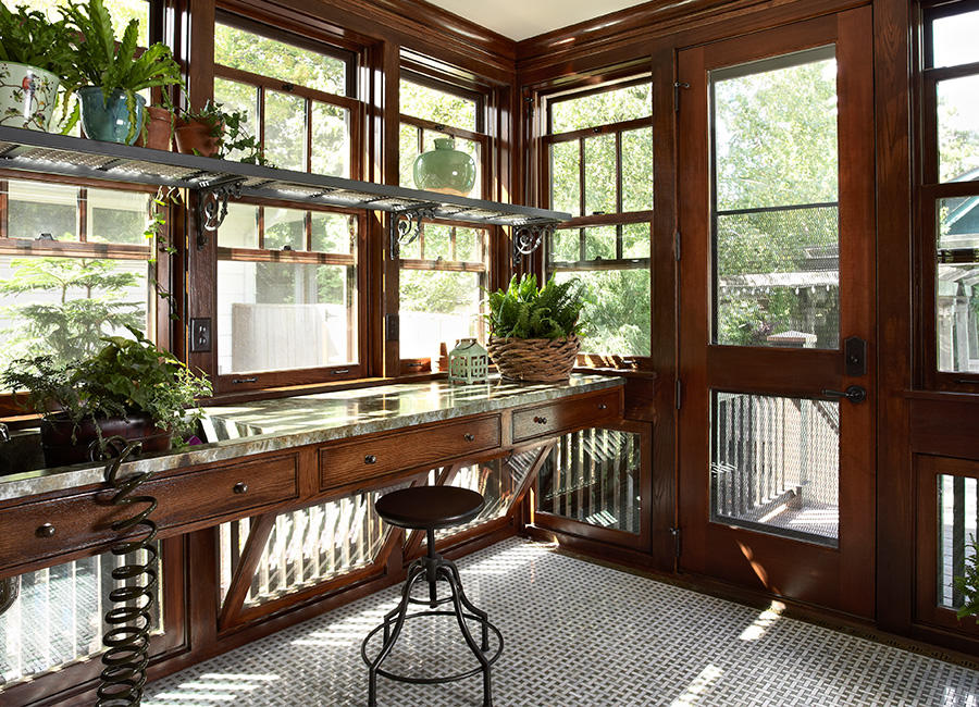 A desk in a sunroom with plants