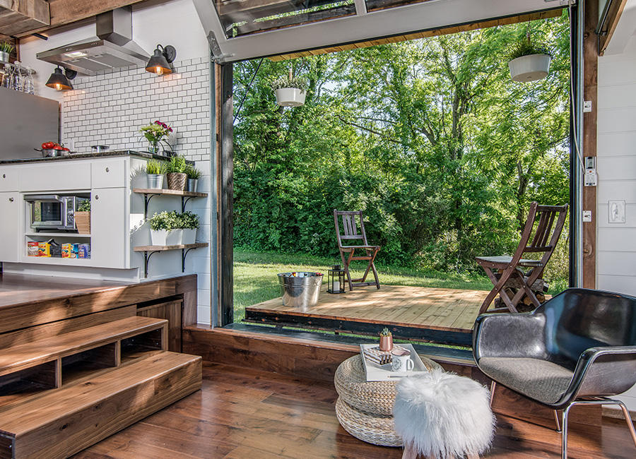 Photo of a living room with an open garage door looking out to nature