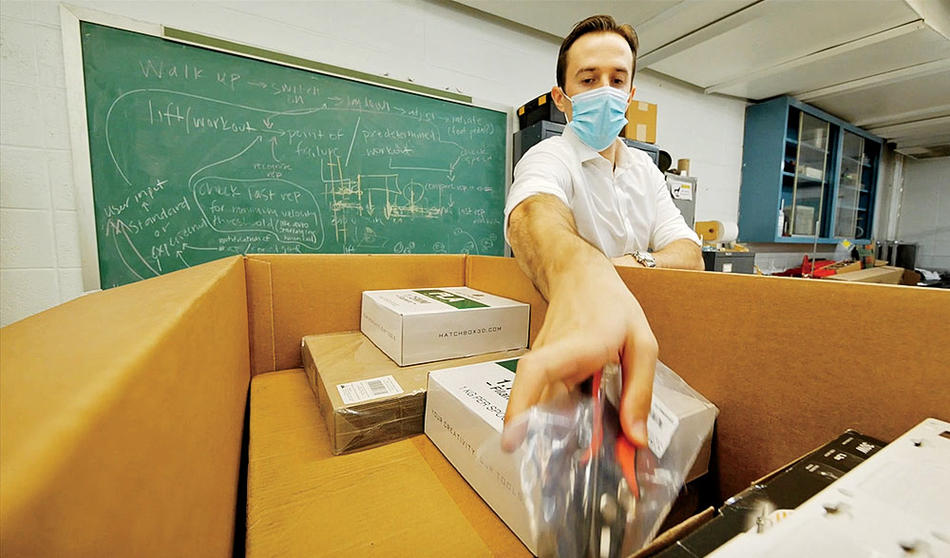 A Columbia engineering student with a box of take-home lab supplies