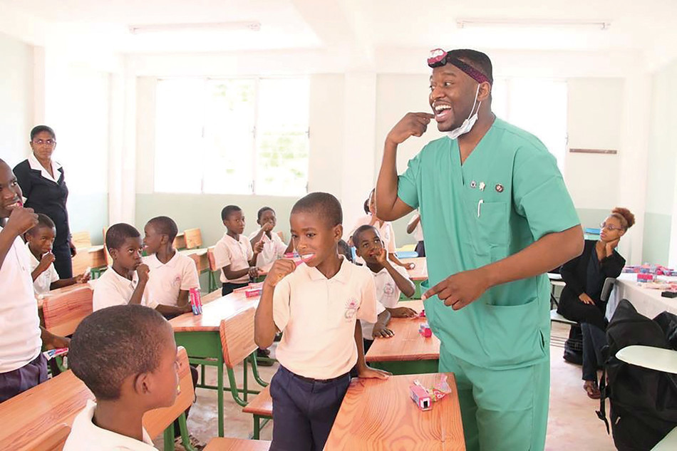 Jean Paul Laurent, founder and CEO of Unspoken Smiles, teaching Haitian schoolchildren how to properly brush their teeth