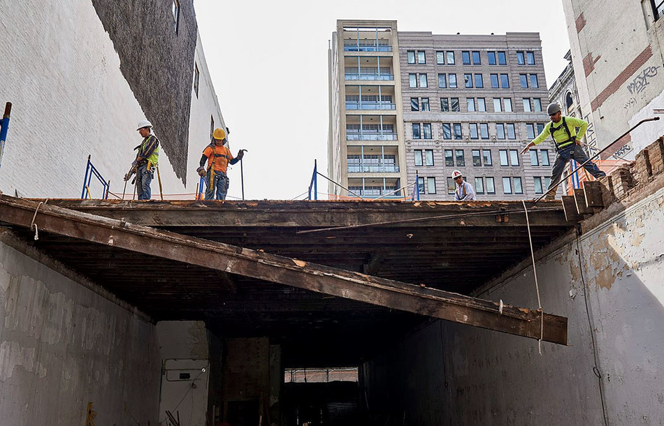 NYC construction workers dropping a ceiling joist from the remains of an 1880s commercial building.