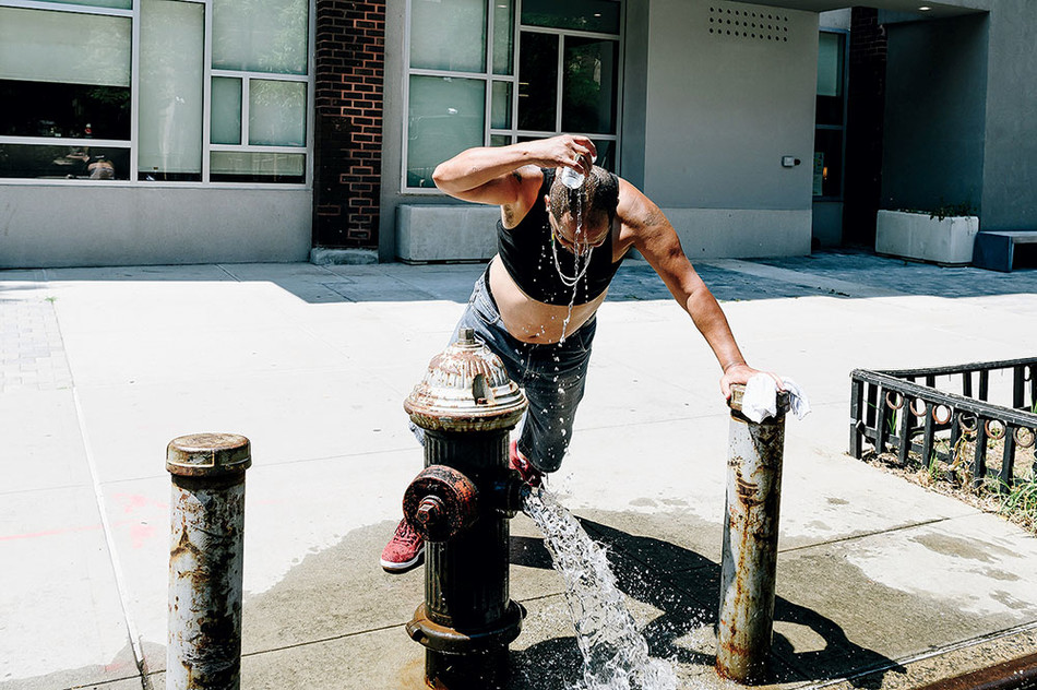 Man cooling off in a fire hydrant