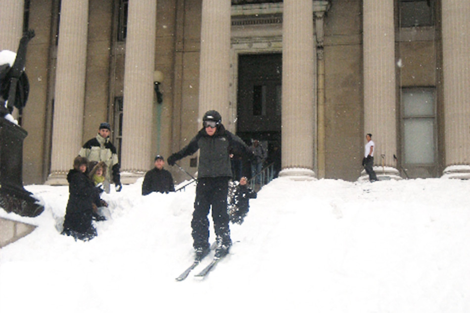 A person skiing down Columbia Low Library's steps after a heavy snow