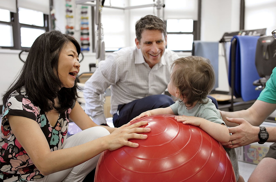 Columbia clinicians Lisa Yoon and Jason Carmel work with a young patient at the Weinberg Family Cerebral Palsy Center