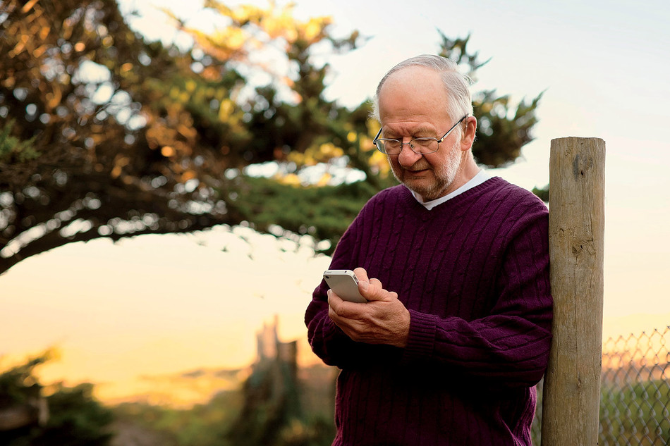 elderly man looking at mobile phone