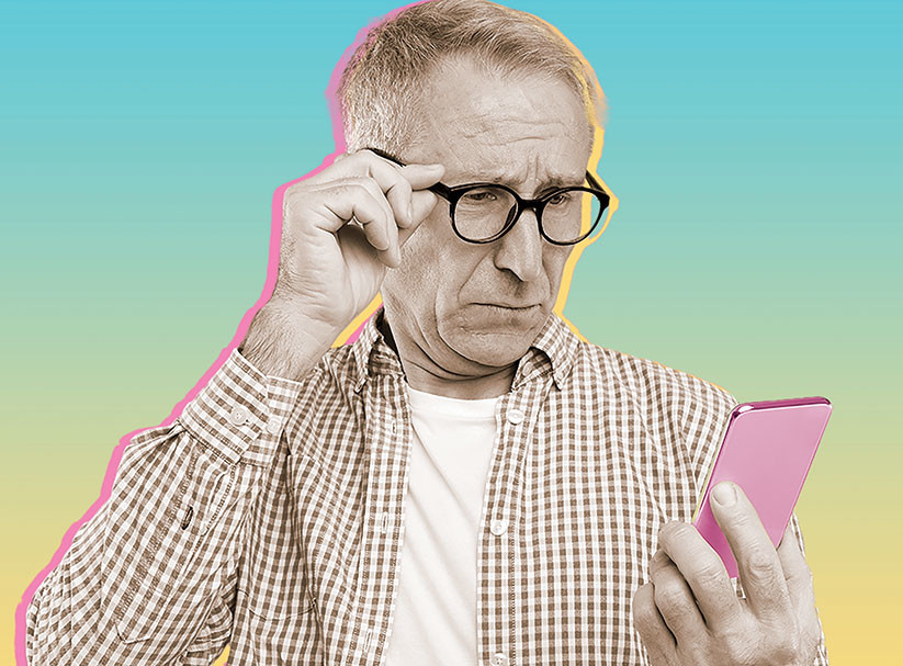 A man looking at his phone against a colored background