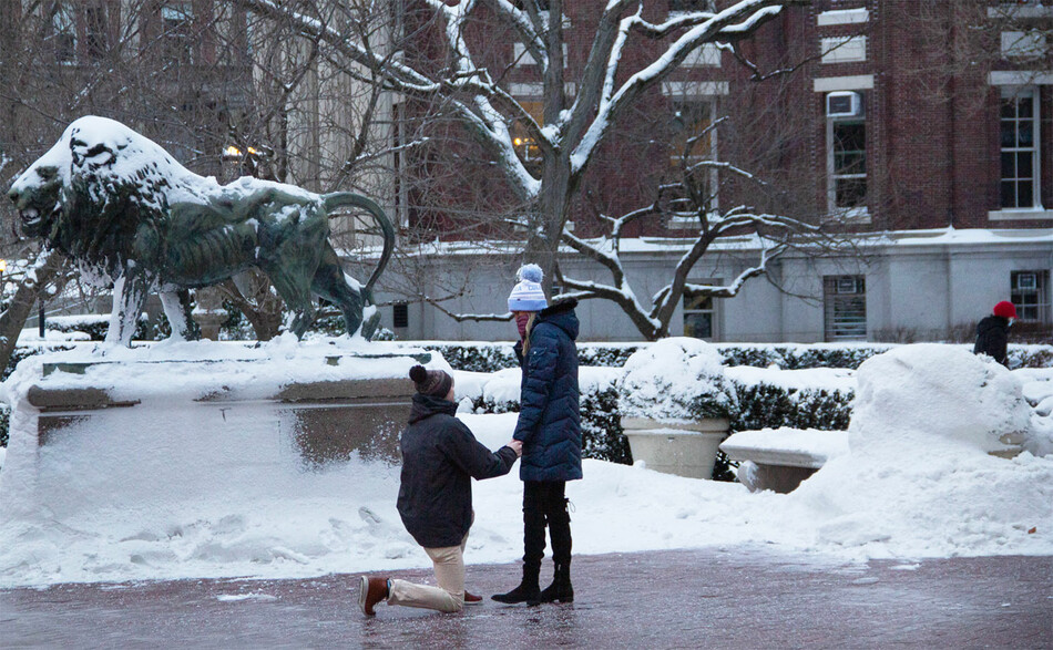 A couple gets engaged next to Columbia University lion sculpture