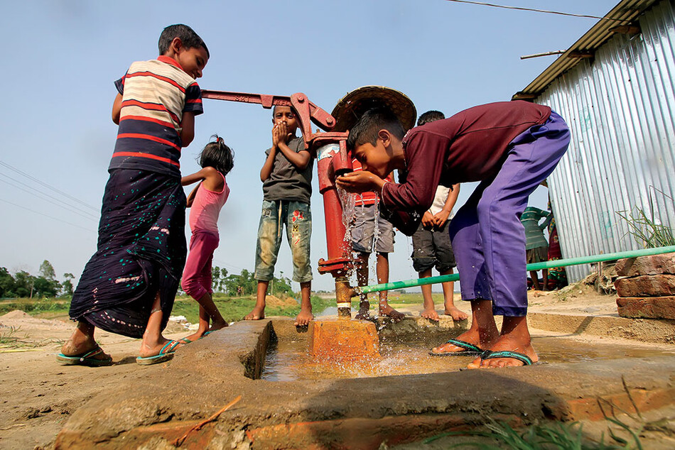 Children drinking water from a well in Bangladesh