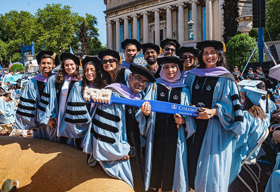 Graduates of Columbia's dental school holding a toothbrush at commencement 2026