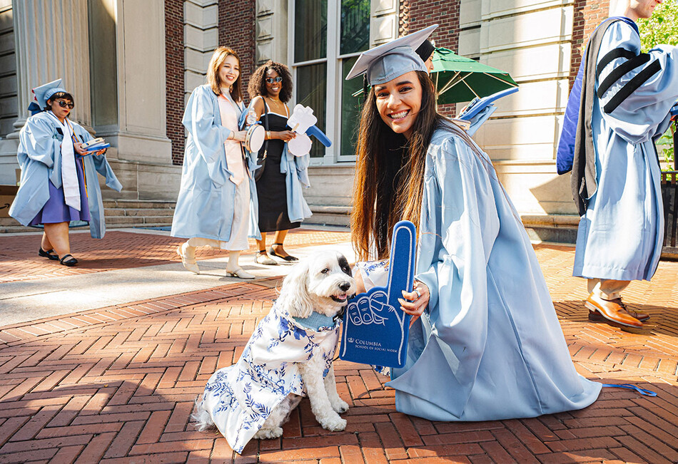 A Columbia graduate with a dog at 2026 Commencement